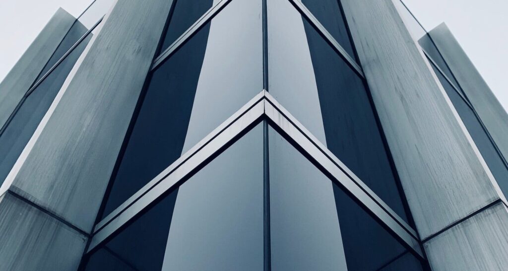 foto de edificio con aristas, en tonos grisáceos y azulados. Fachada acristalada