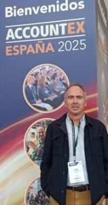 Foto de un señor de pie frente a cartel Accountex 2025